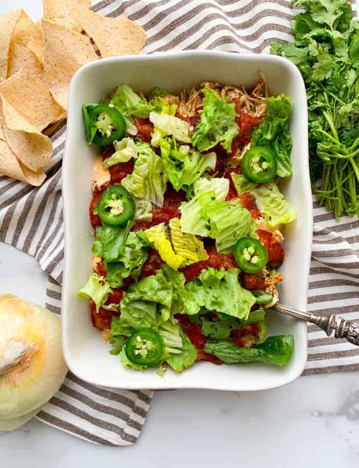 A white casserole dish filled with taco dip.