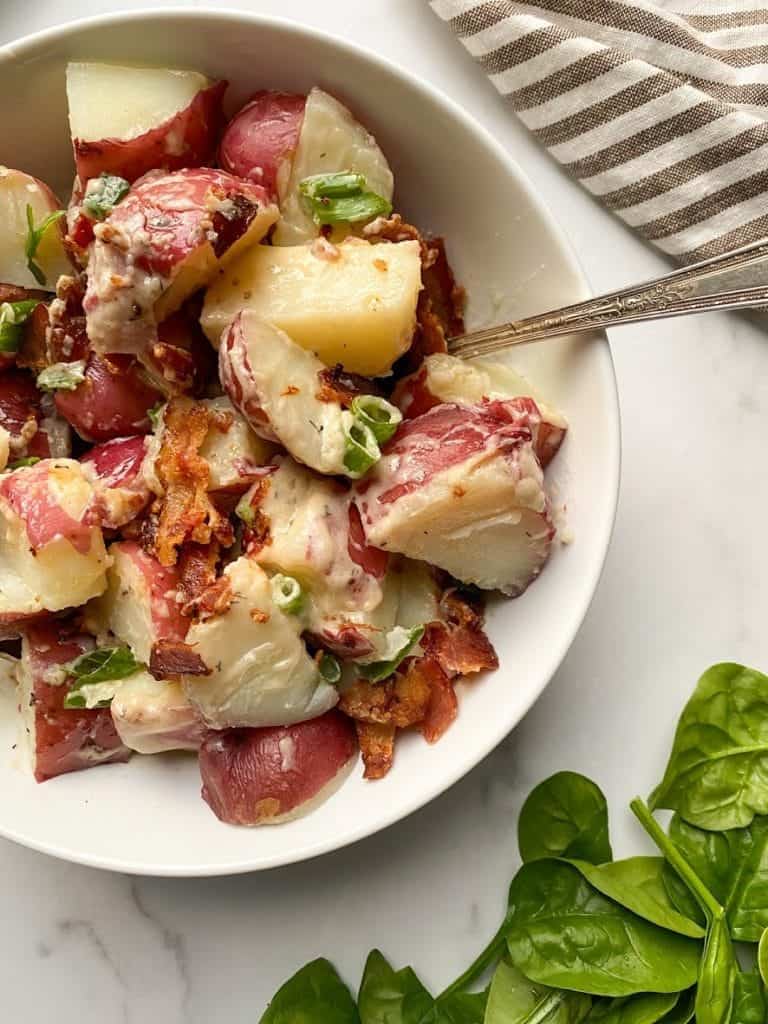 Whole30 potato salad with bacon and green onions.