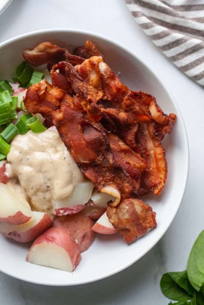 Ingredients for potato salad in a white bowl.