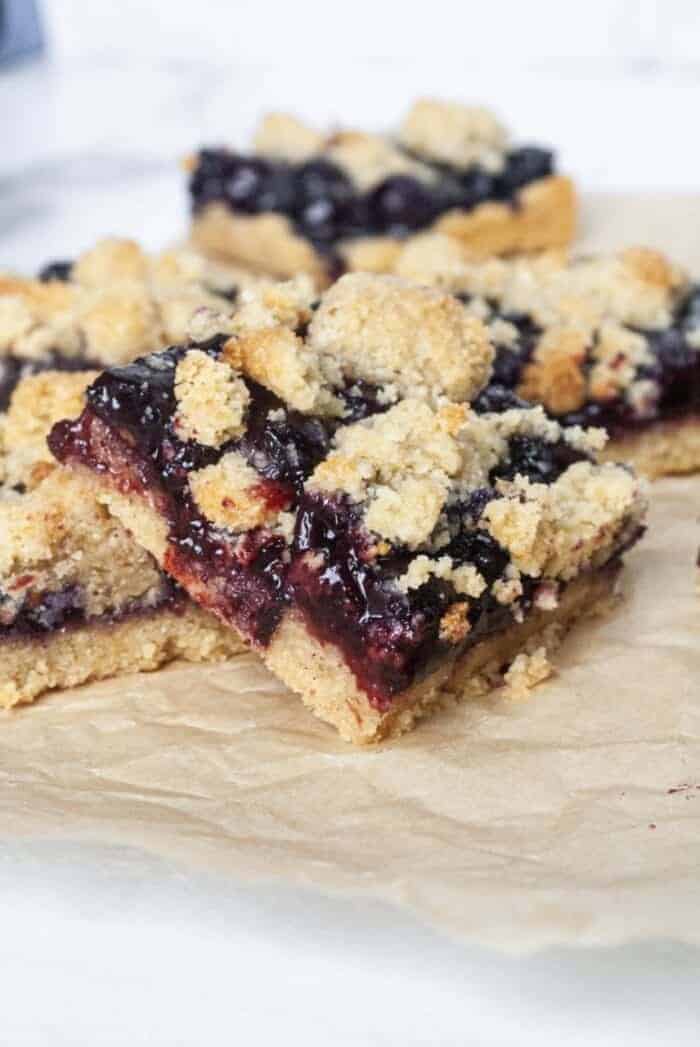 Paleo Blueberry Crumb Bar on a sheet of beige parchment paper.