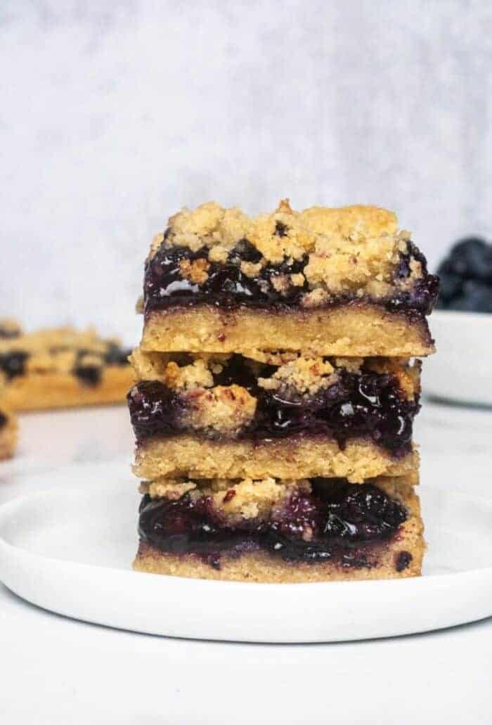 A stack of Paleo Blueberry Crumb Bars on a white plate.