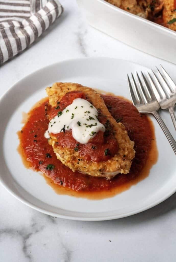 A white plate with Whole30 chicken parmesan.