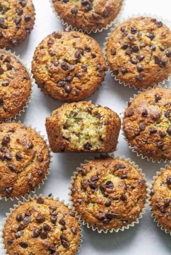 Paleo chocolate chip zucchini muffins on a neutral backdrop.