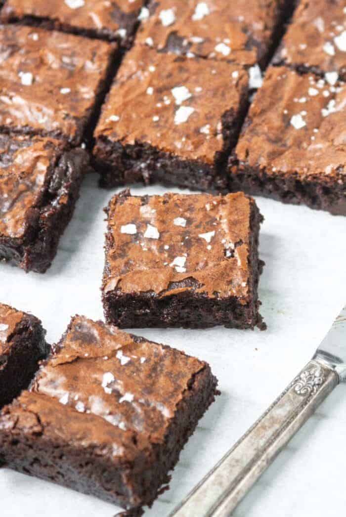 Paleo and Gluten free brownies on a piece of white parchment paper.