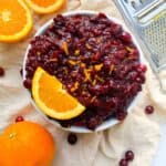 Paleo cranberry sauce in bowl with sliced orange