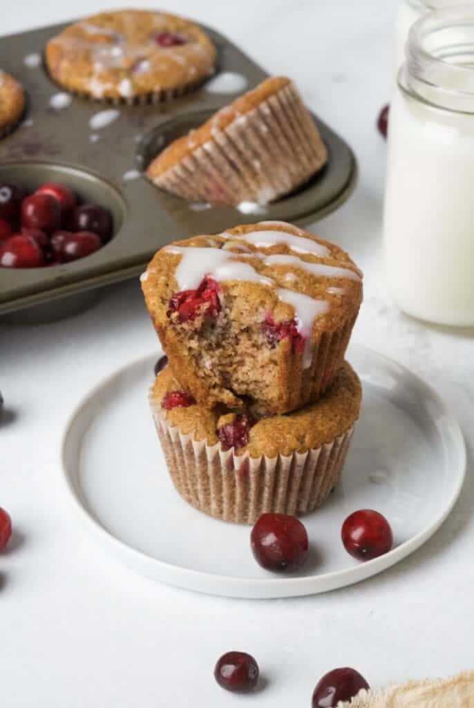 Paleo Orange Cranberry Muffins on a white plate with a glass of milk.