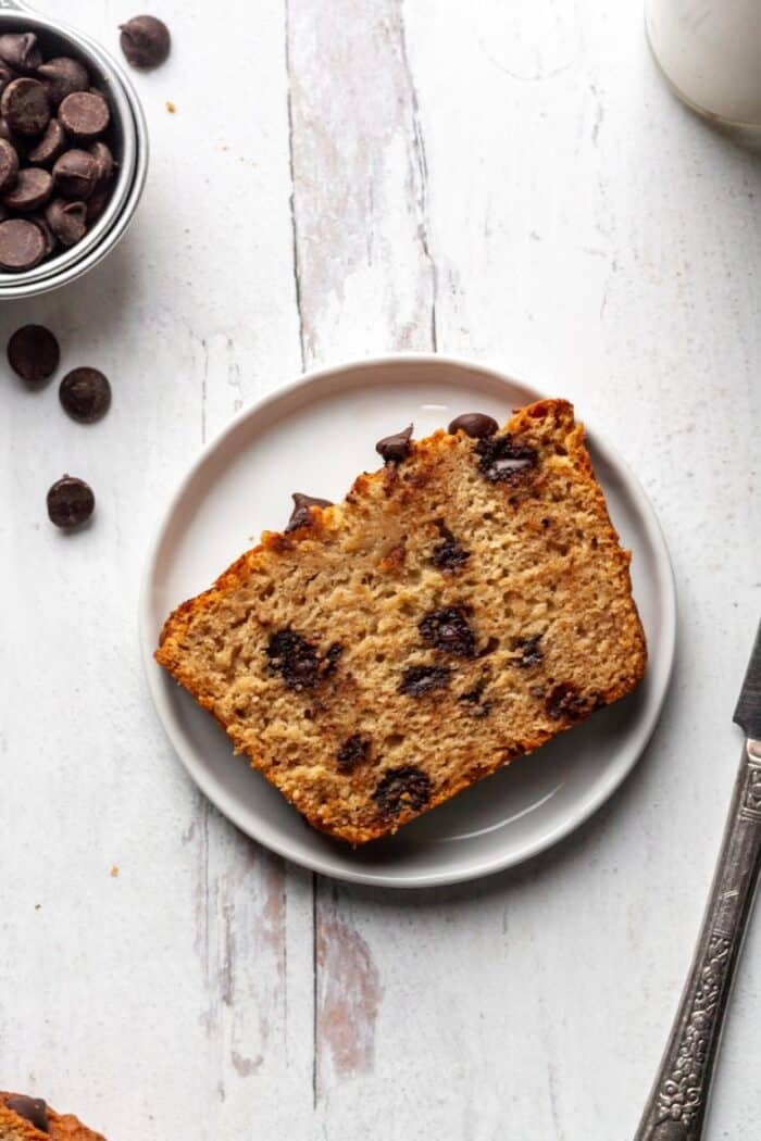 A piece of Paleo chocolate chip banana bread on a white plate.