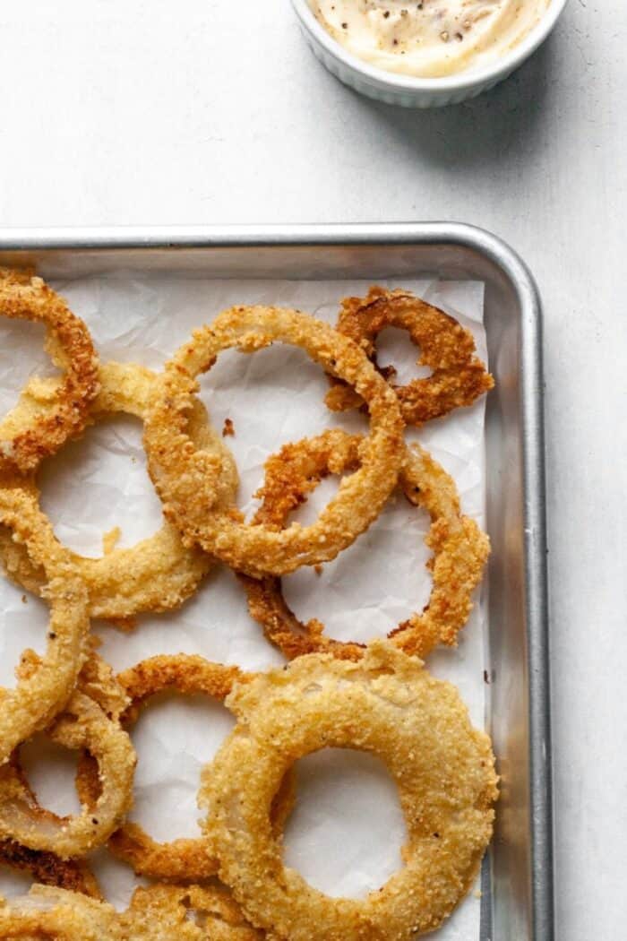 A baking sheet with onion rings.