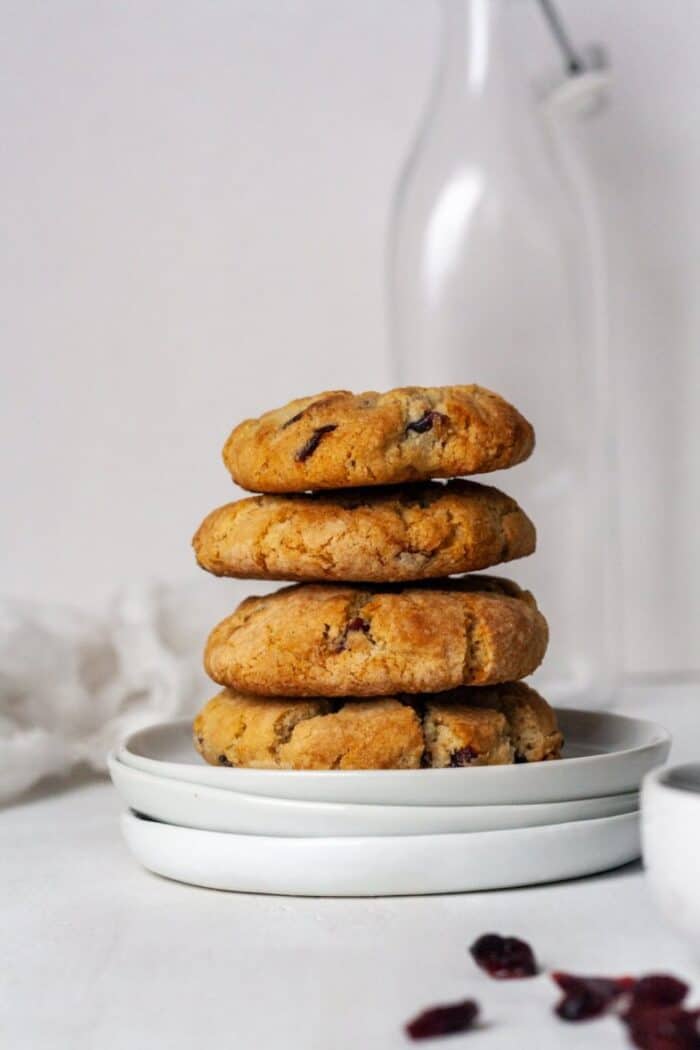 A stack of orange cranberry cookies on a white plate.
