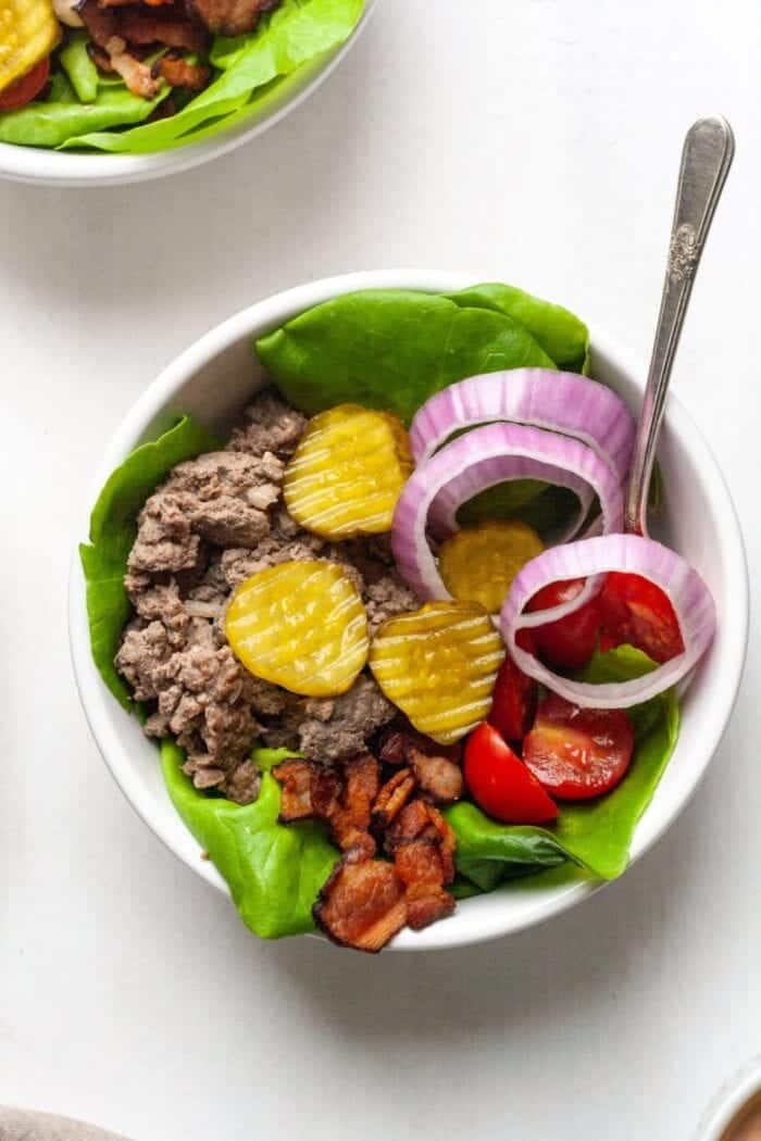 Whole30 Burger Bowls in a white bowl with a silver fork.