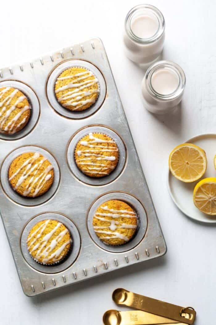 Paleo Lemon Poppy Seed muffins on a silver muffin tray.