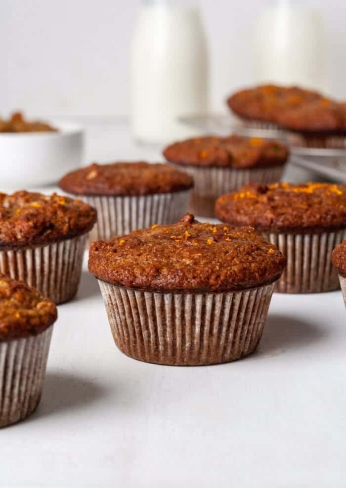 Paleo Morning Glory Muffins on a white backdrop with milk.