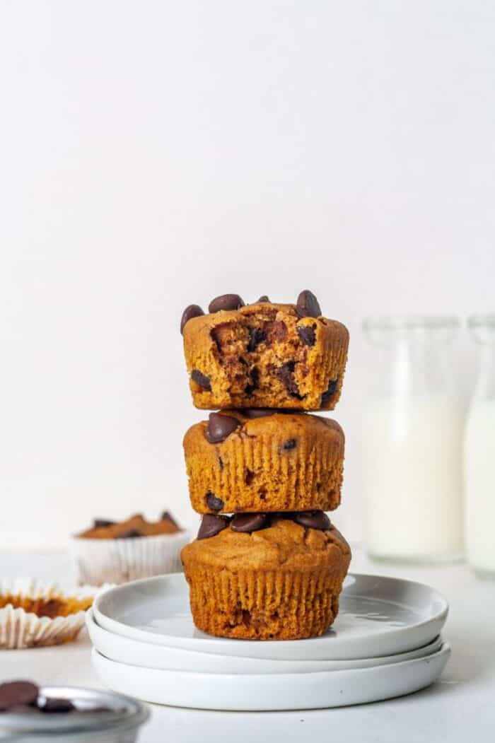A stack of three Flourless Paleo Pumpkin Muffins on white plates.