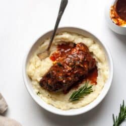 A white bowl filled with Paleo Braised Short Ribs on a white backdrop.
