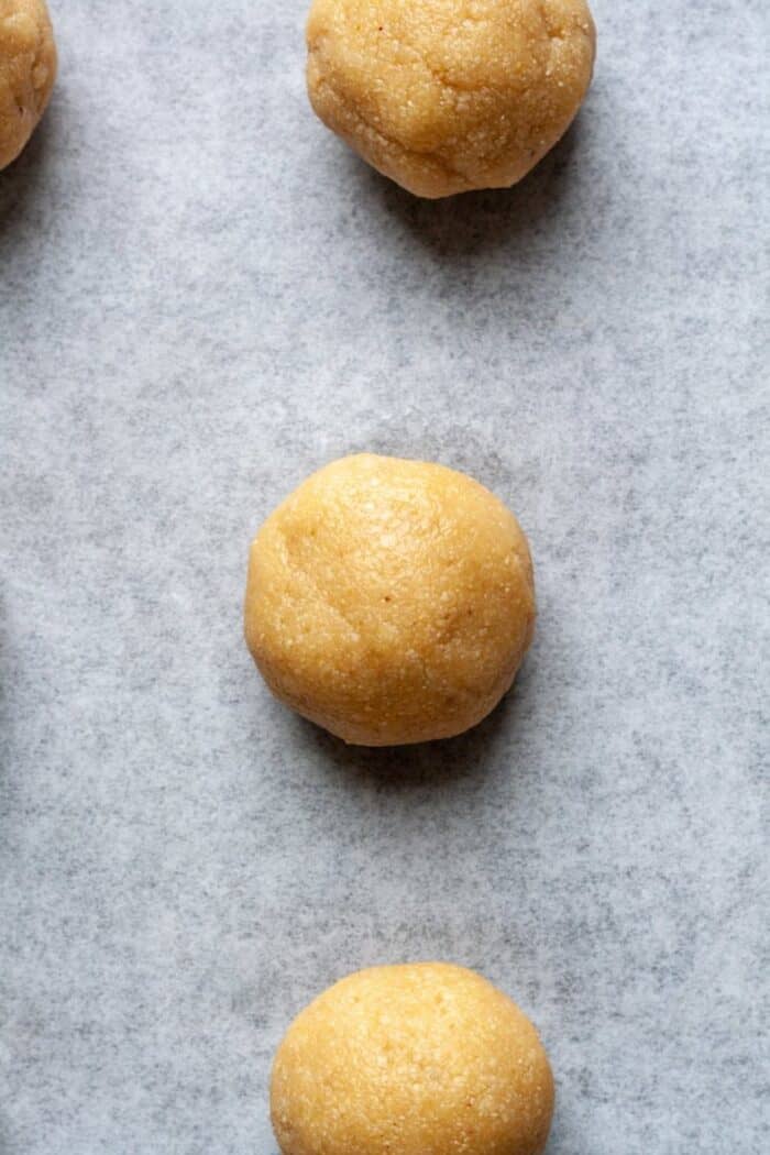 Almond flour thumbprint cookie dough on parchment paper.