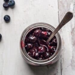 A glass jar filled with Vegan Blueberry Jam.