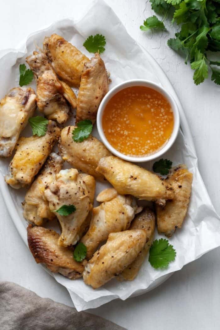 Chicken wings on a white platter.