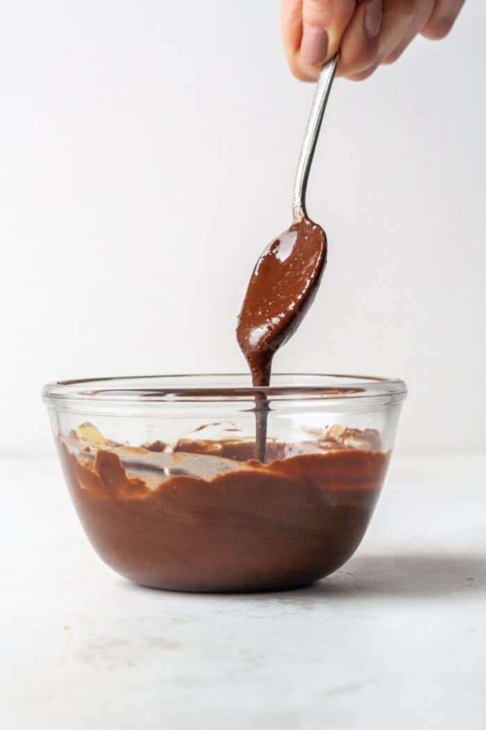 Melted dark chocolate in a glass bowl.