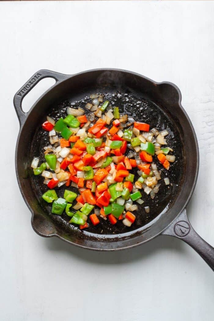 Onions and peppers in a cast iron skillet