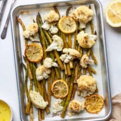 Roasted cauliflower and asparagus with lemon on baking pan