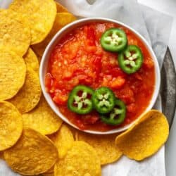 Mango habanero salsa in a white bowl with tortilla chips