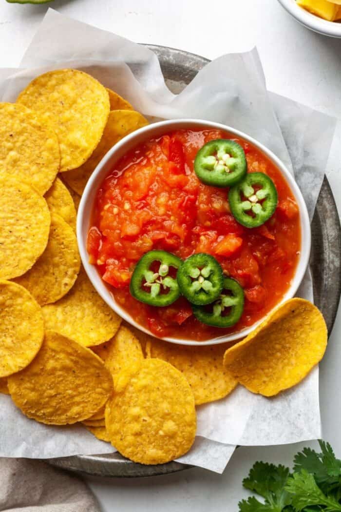 Mango habanero salsa in a white bowl with tortilla chips