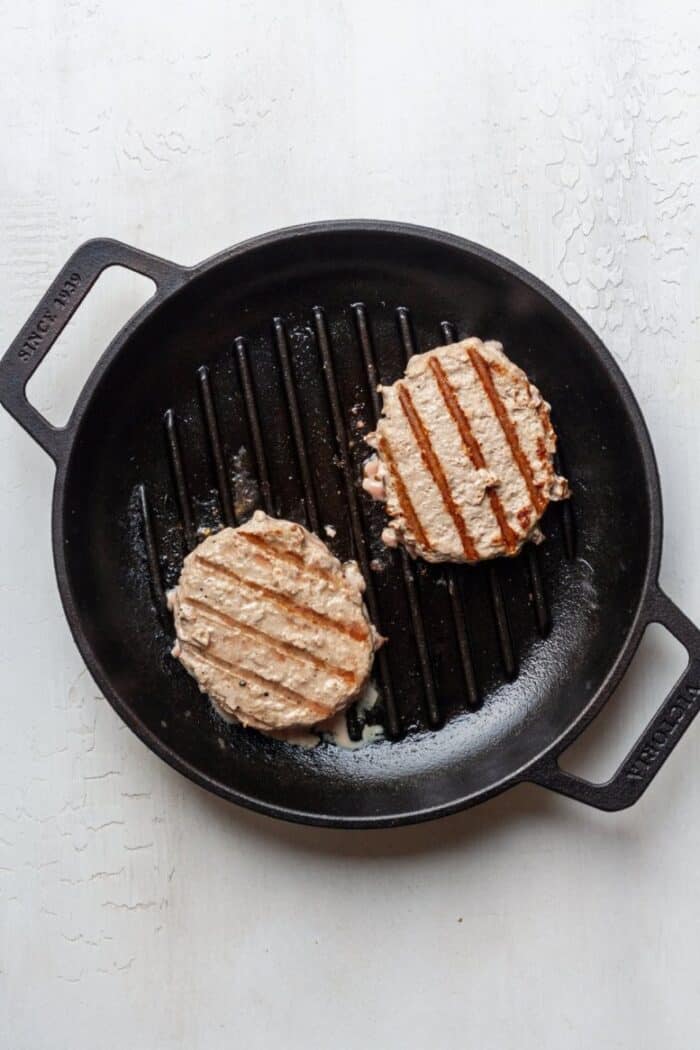 Cooked turkey burgers in cast iron skillet