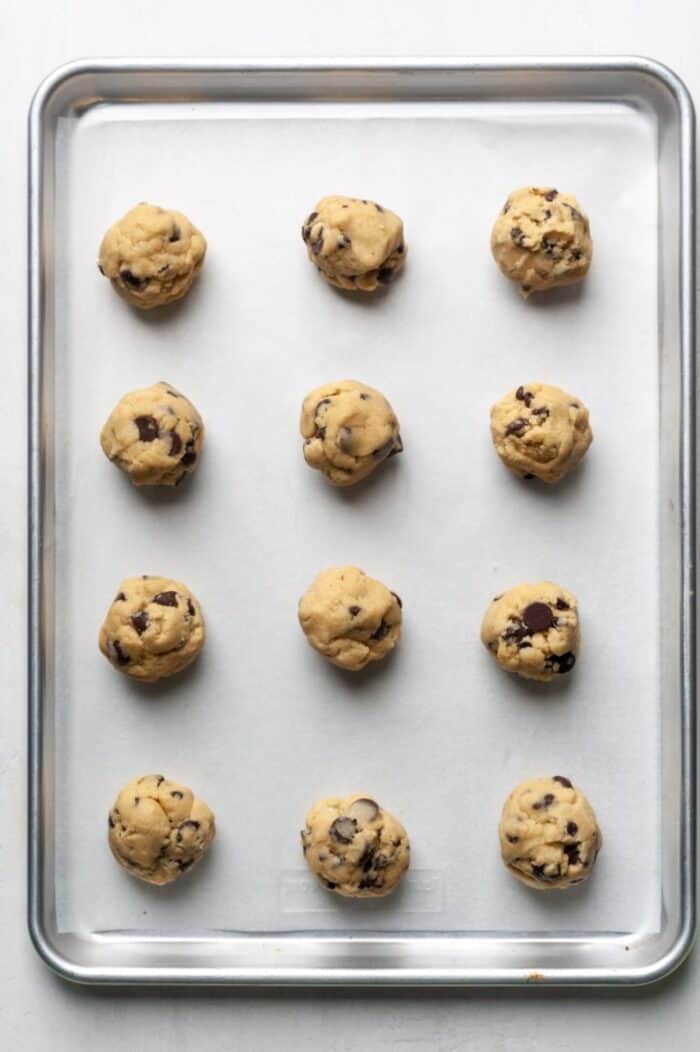 Cookie dough balls on sheet.