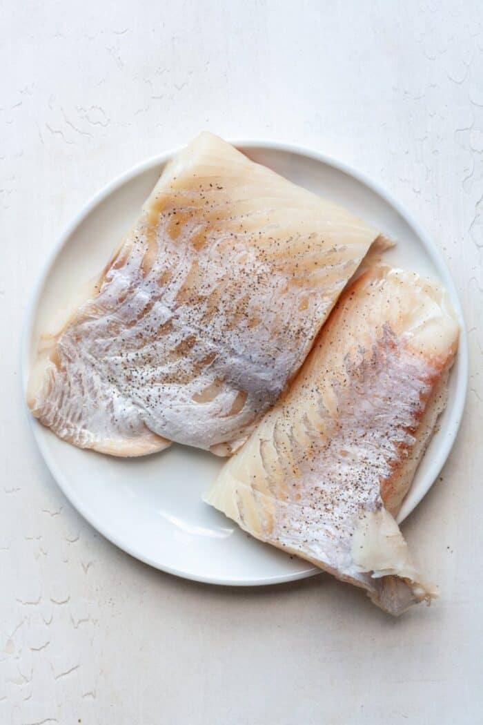 Seasoned sea bass on plate.
