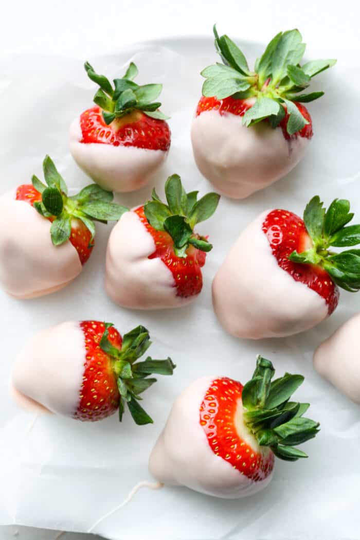 Pink covered strawberries on white plate