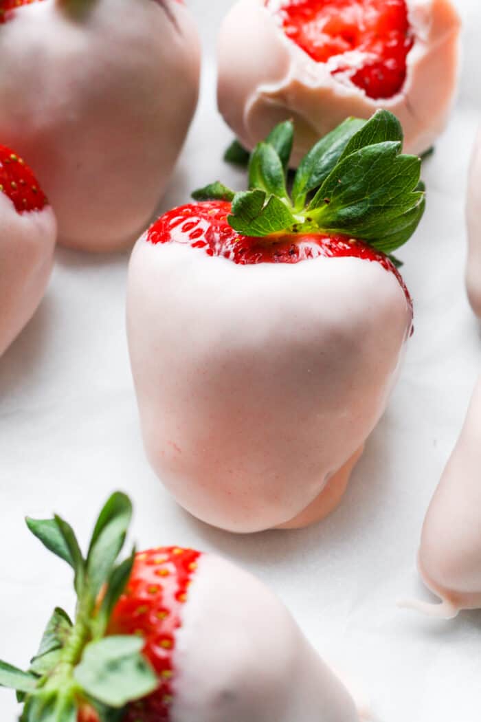 Pink chocolate covered strawberries on white background