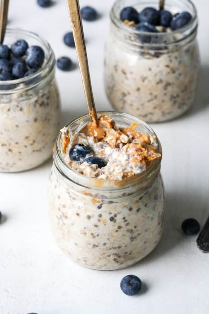 Jars of oatmeal with peanut butter and blueberries