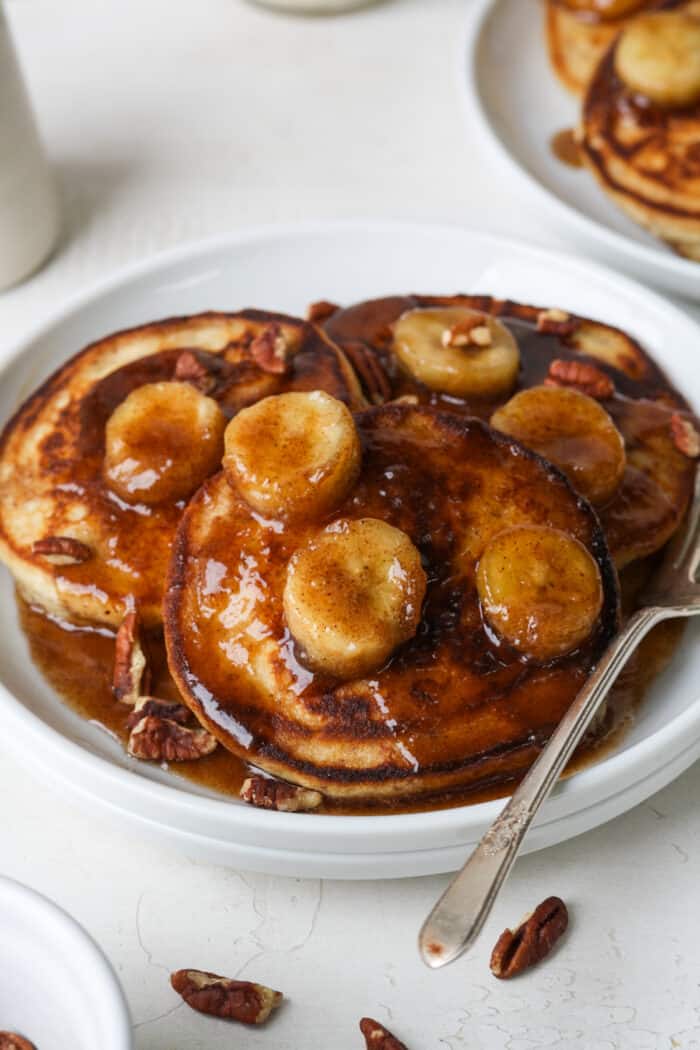 Bananas foster pancakes on white plate