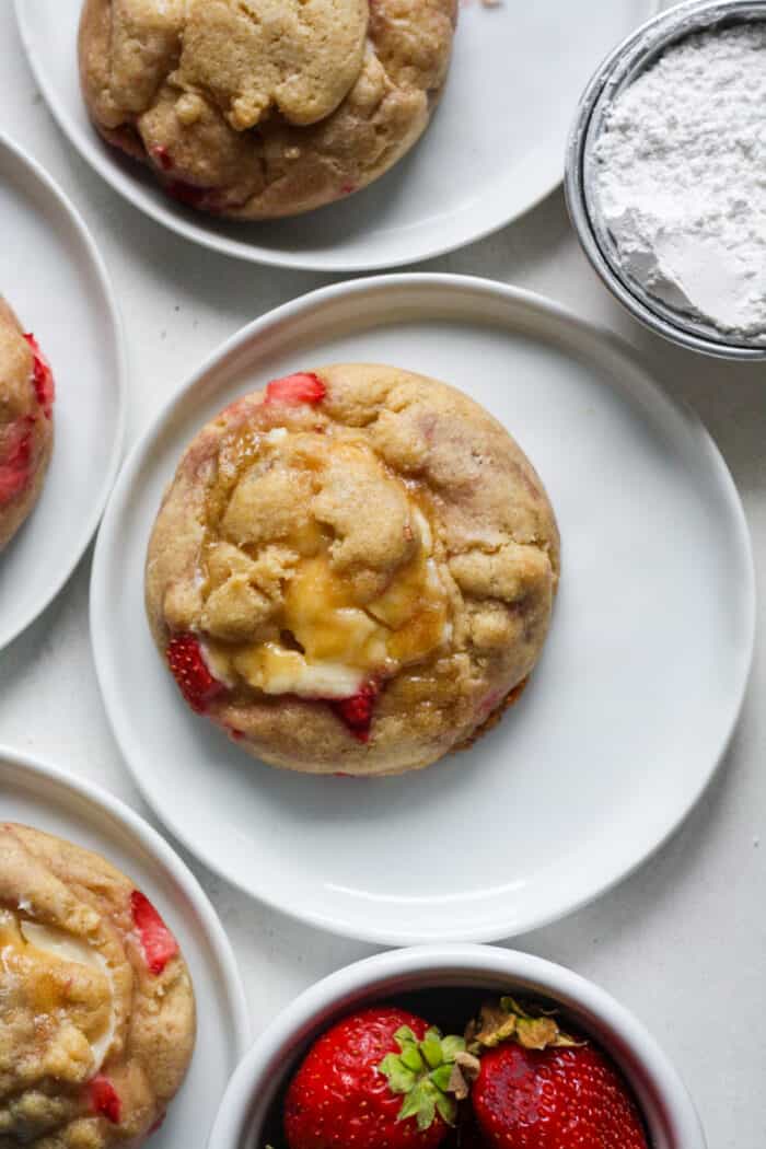 Small white plates with strawberry cheesecake cookies