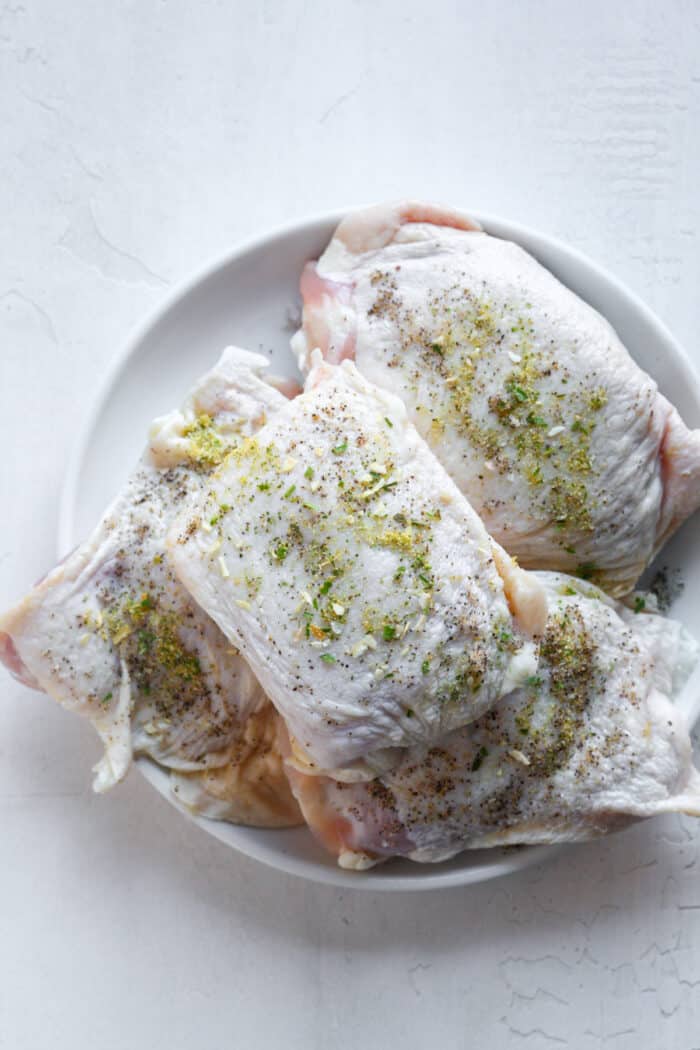 Seasoned chicken thighs on plate