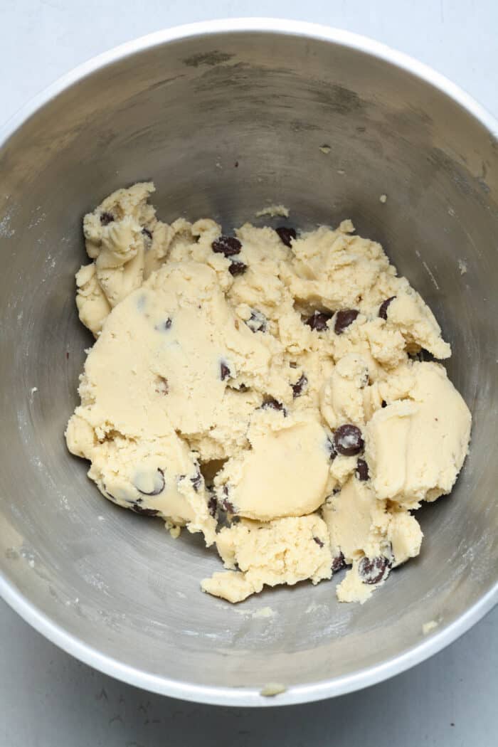 Chocolate chip cookie dough in silver bowl