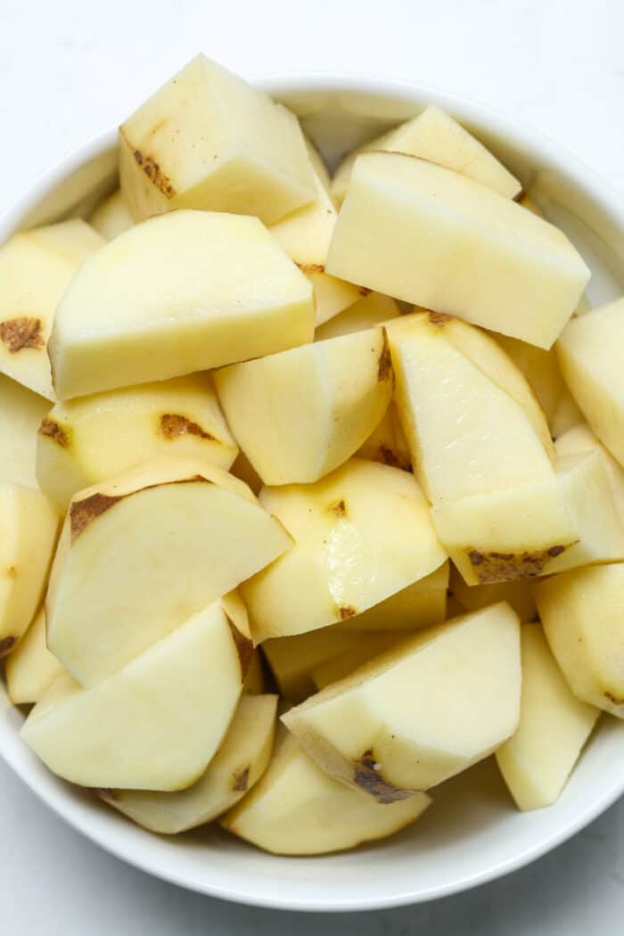 Cubed potatoes in white bowl