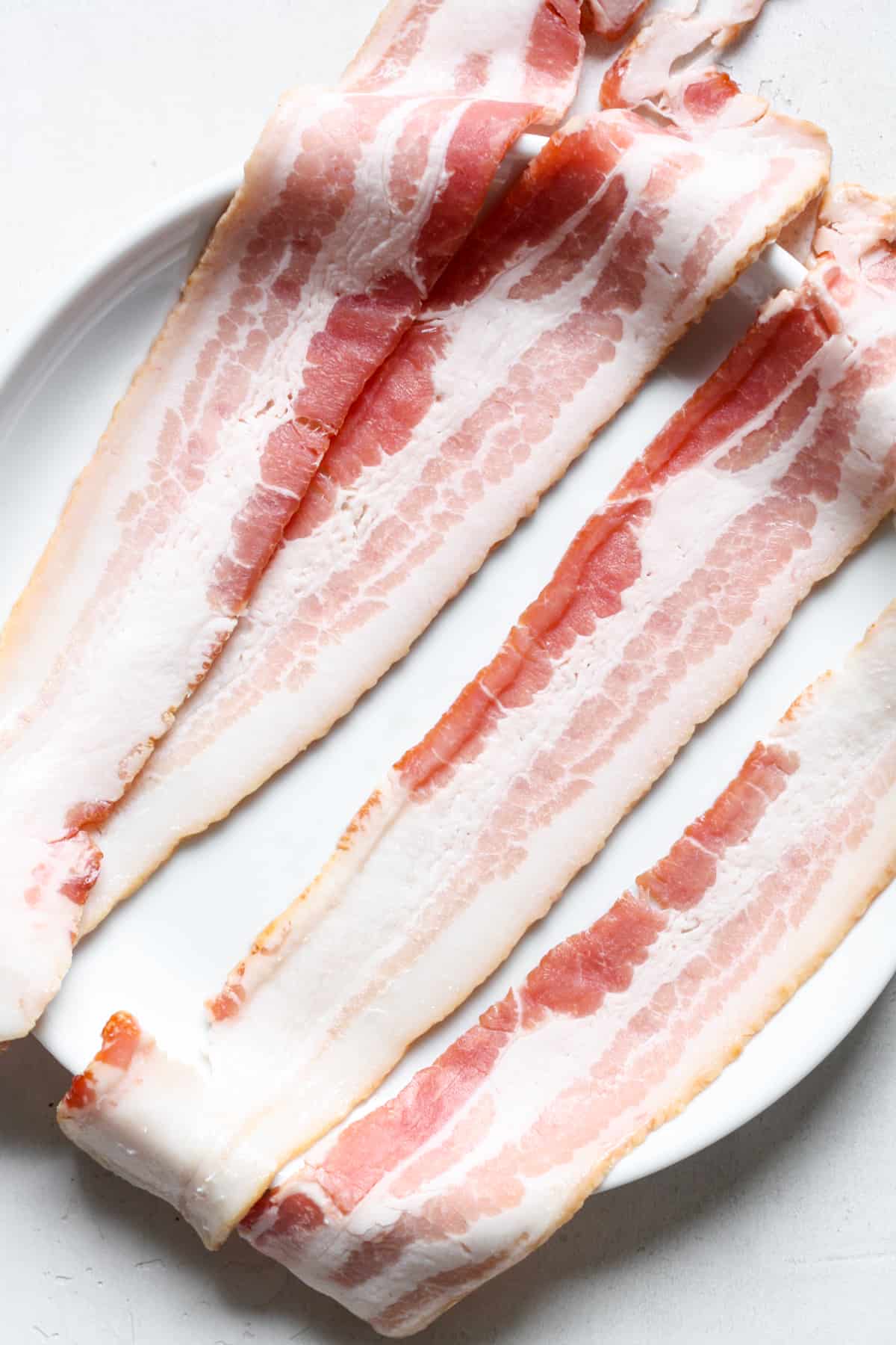 Raw bacon on plate