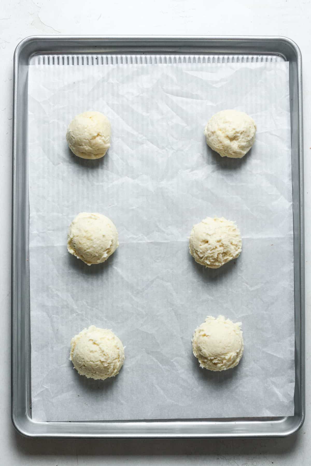 Balls of cookie dough on pan.