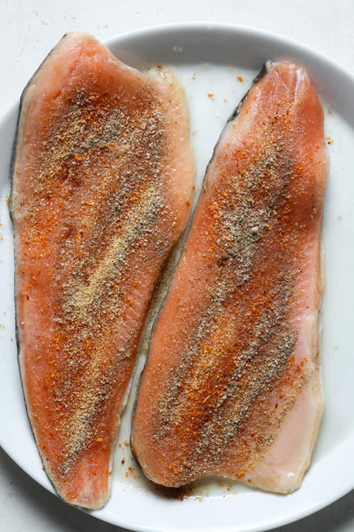 Seasoned fish on plate.