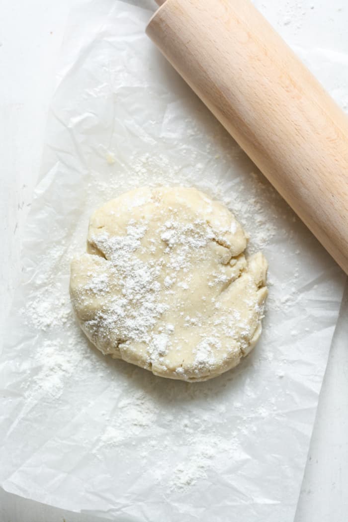 Disc of gluten free pie dough with rolling pin.