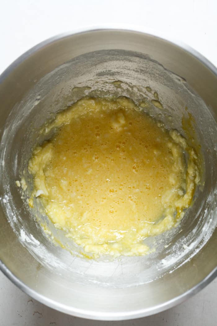 Eggs and sugar with butter in bowl.