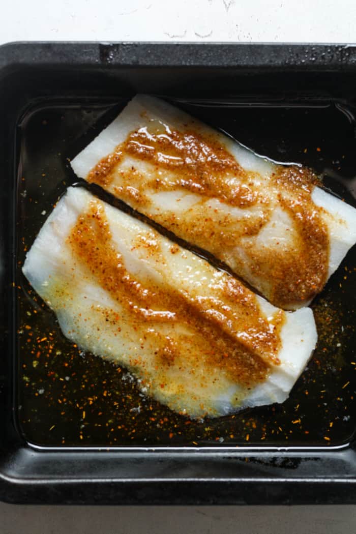 Seasoned fish in pan.