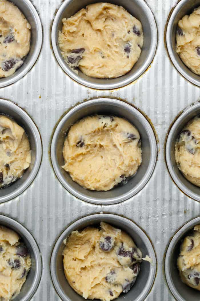 Muffin pan with cookie dough.