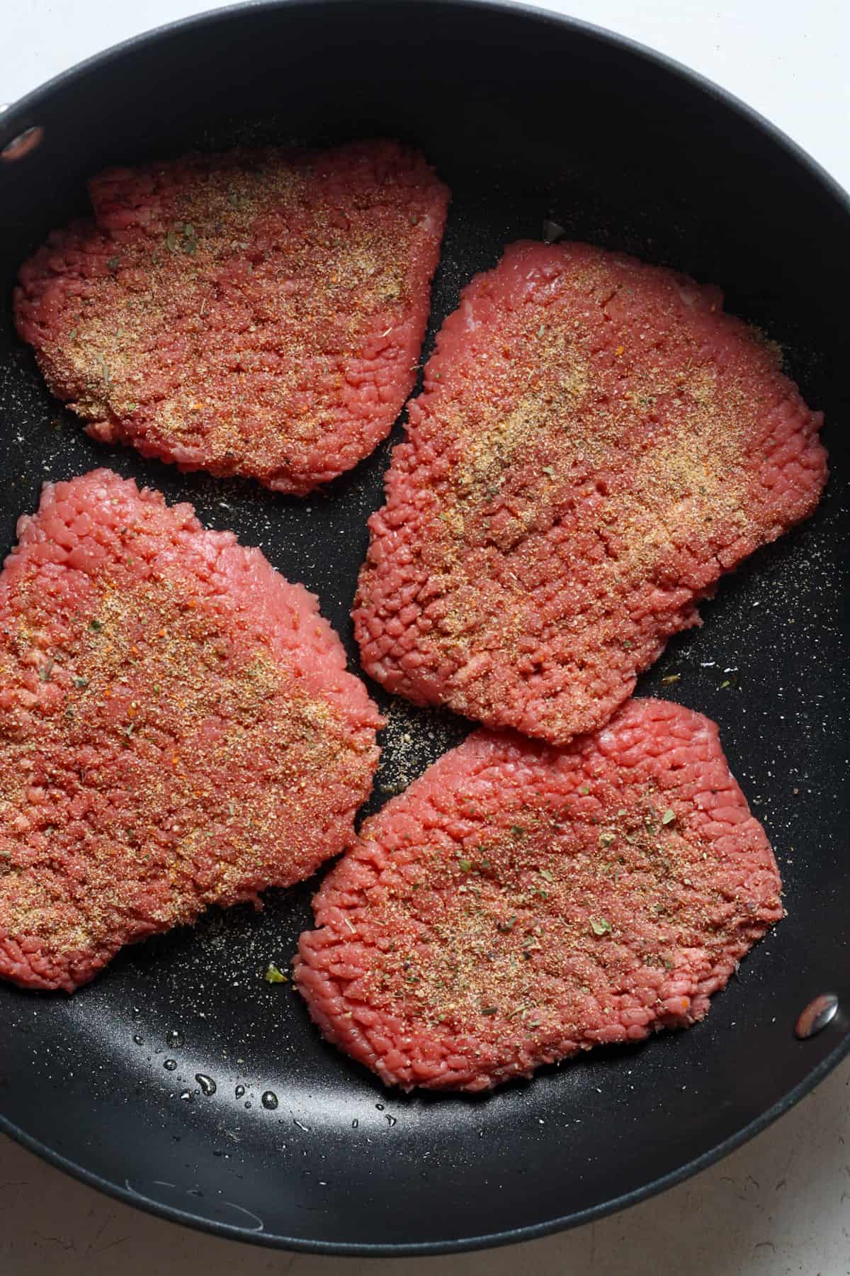 Beef cubed steaks in pan.
