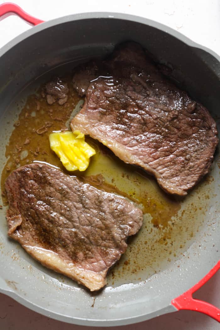 Butter steak in pan.
