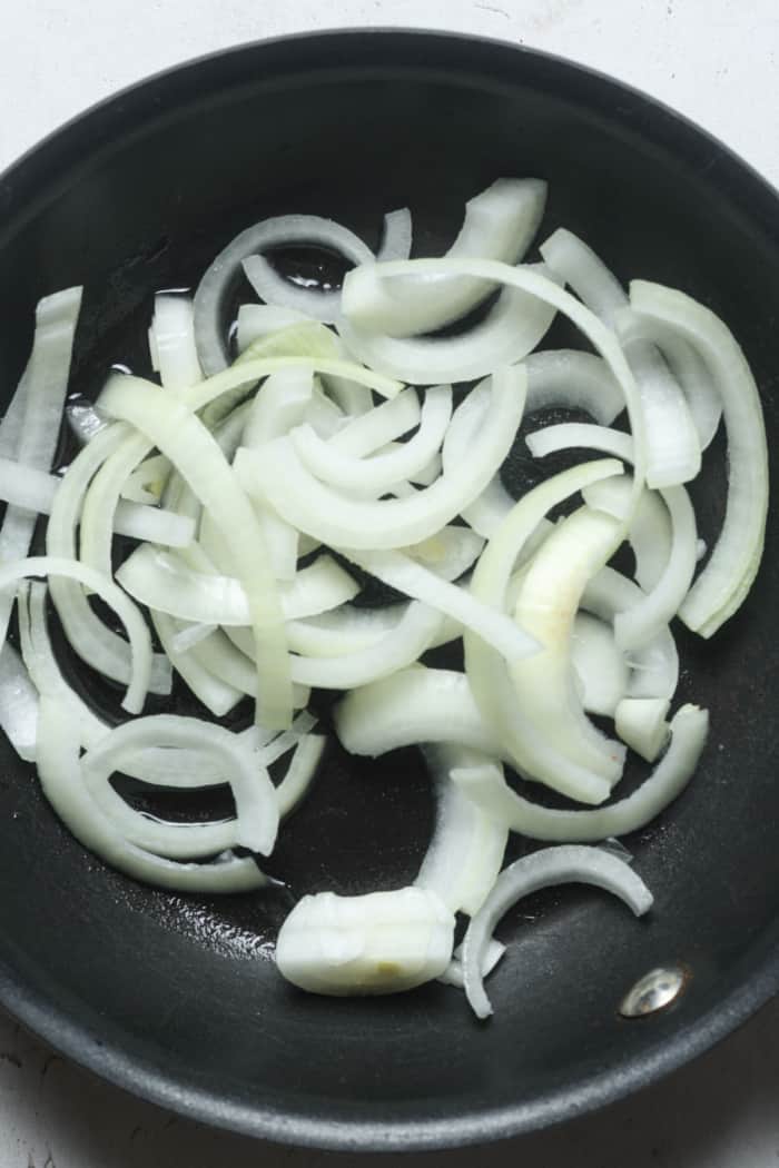 Sliced onions in pan.