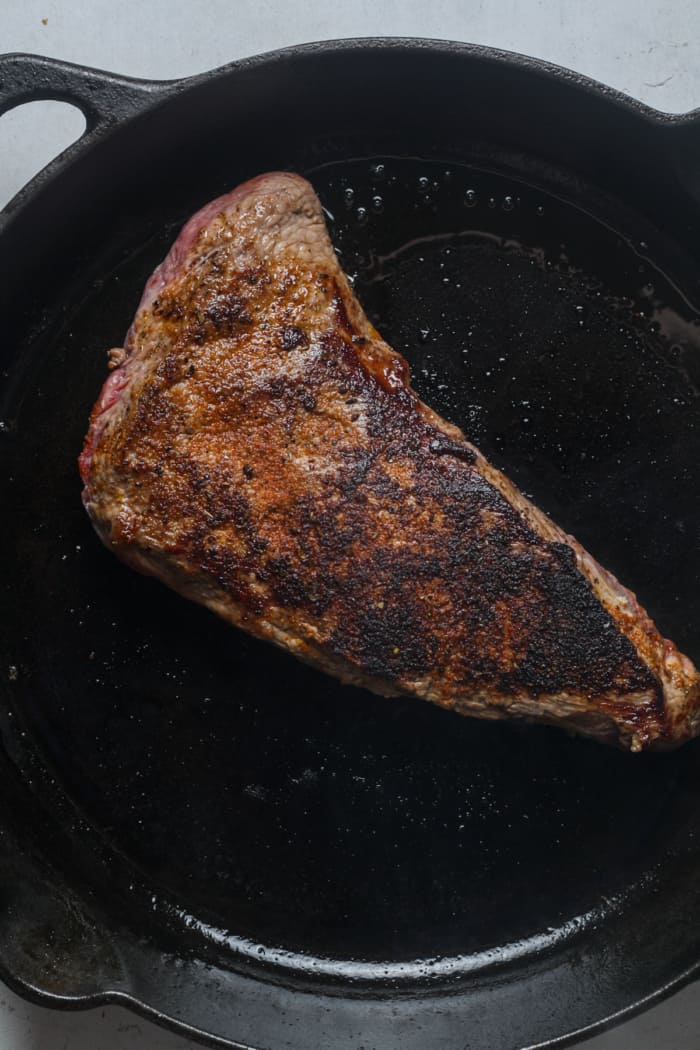 Seared steak in pan.