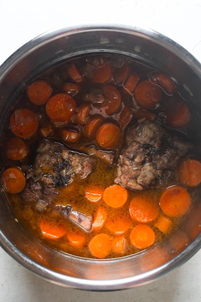 Meat and carrots in pot.