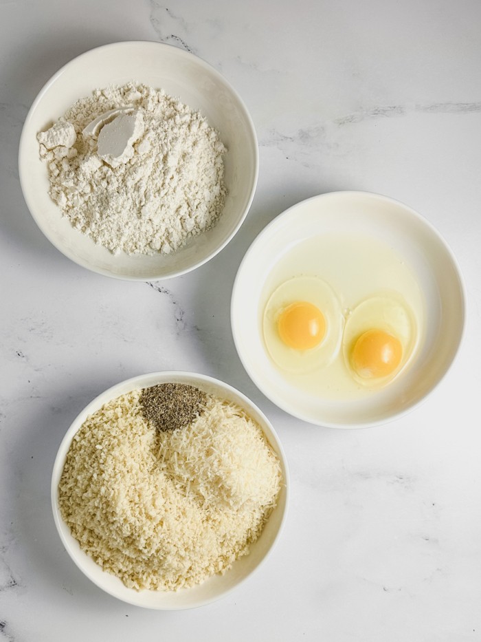 Eggs and seasonings in bowls.